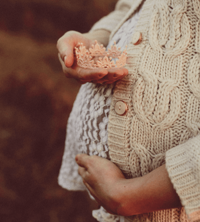 pregnant woman holding lace crown